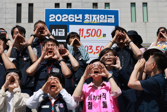 '모두를 위한 최저임금 운동본부'와 양대노총 조합원들이 11일 서울 종로구 세종문화회관 계단에서 내년에 적용할 최저임금 요구안을 발표하고 있다. [연합뉴스]